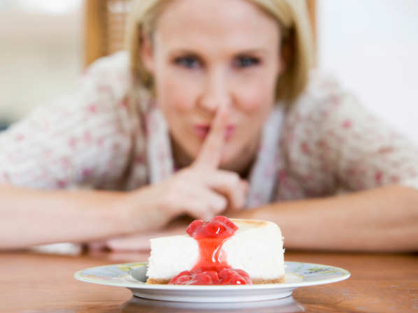 Woman Tempted By Slice Of Strawberry Cheesecake